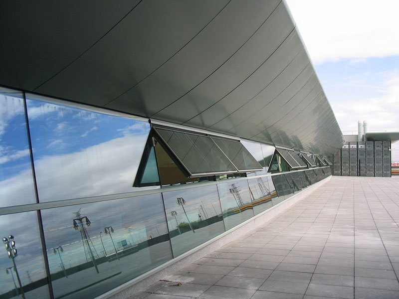 Bild zeigt eine moderne Fensterfassade mit geöffnetem Flügel, der über einen Kettenantrieb elektrisch betätigt wird.